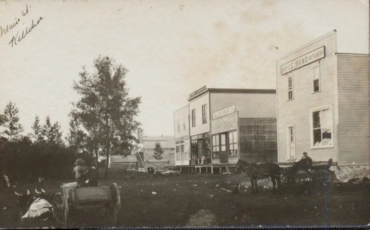 Main Street, Kelliher, with early wooden stores and wagons, about 1910
